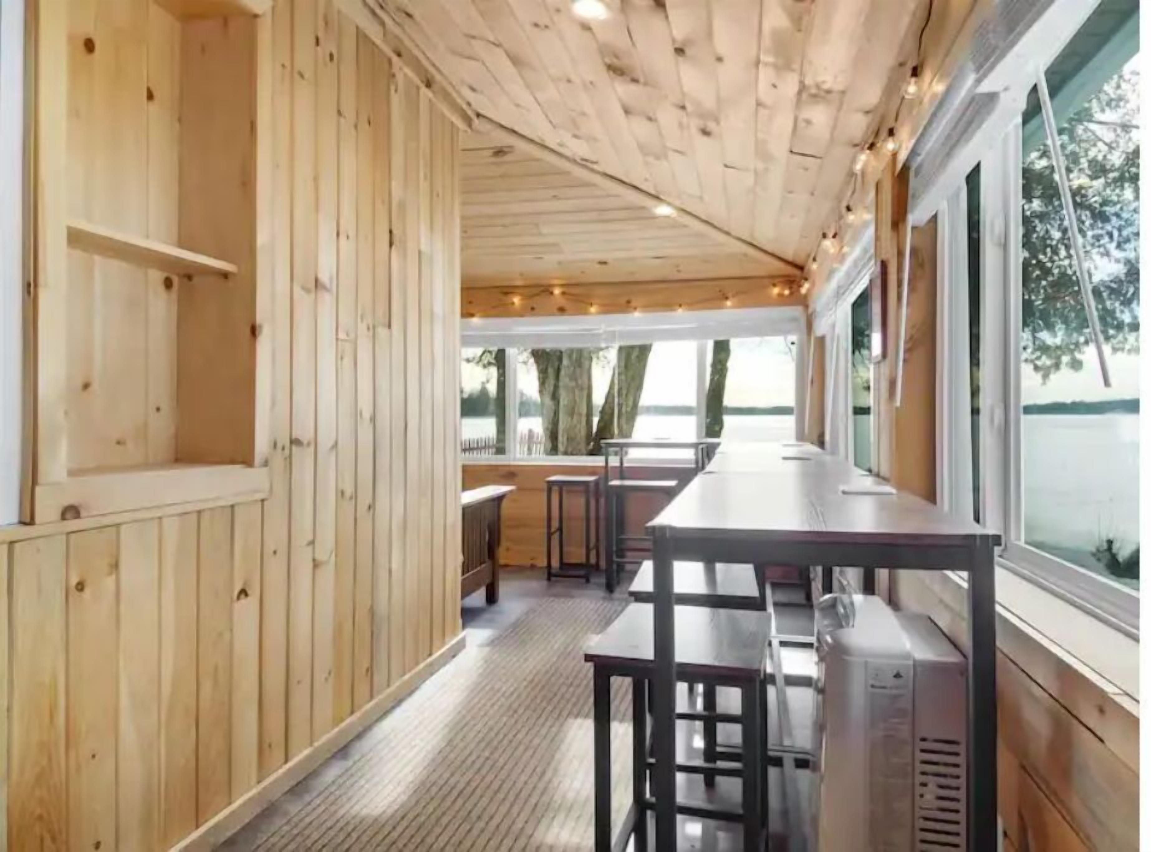 Expanded dining area overlooking lake including easy access to the hot tub/lake.