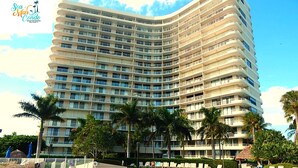 A large, multi-story hotel with a pool area.