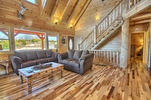 A wooden interior with a sofa, coffee table, and a staircase. - Lone Star Lodge - Gorgeous Lodge in Hocking Hills (Logan)