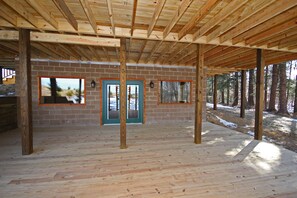 A building under construction with exposed wooden beams, brick walls, and large windows. - Lone Star Lodge - Gorgeous Lodge in Hocking Hills (Logan)