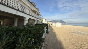 A beachfront hotel with a sandy beach, a clear sky, and a distant mountain. - M170 - Marcelli, Wonderful attic with sea view (Marcelli)
