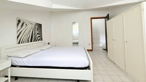 A bedroom with a bed, a nightstand, a wardrobe, and a mirror. - M170 - Marcelli, Wonderful attic with sea view (Marcelli)