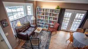 Una sala de estar acogedora con un sofá de cuero, una mesita de centro y una estantería llena de libros.