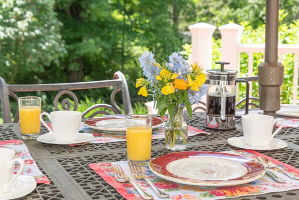 A table set for breakfast with plates, cups, and a glass of orange juice. - Sinclair Inn Bed and Breakfast (Jericho)