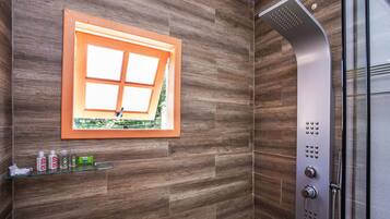 Un baño moderno con ducha, una ventana de madera y un estante con artículos de aseo.