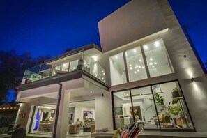 A modern two-story house with large windows, a balcony, and a well-lit interior. - Troy Dr - Sleek & Modern Hollywood Hills Home With Stunning Views (Los Angeles)