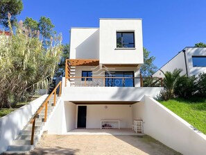 A modern two-story house with a balcony, a staircase, and a small outdoor seating area. - Villa ALOITA (SEIGNOSSE)