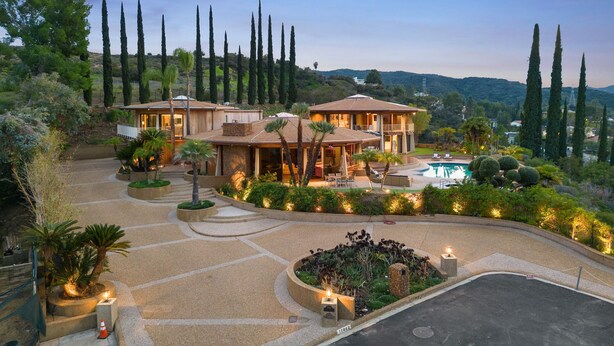 A large, two-story house with a pool, surrounded by landscaped gardens and tall trees. - Via Vallarta - An Architecturally Significant California Modern Home (Encino)