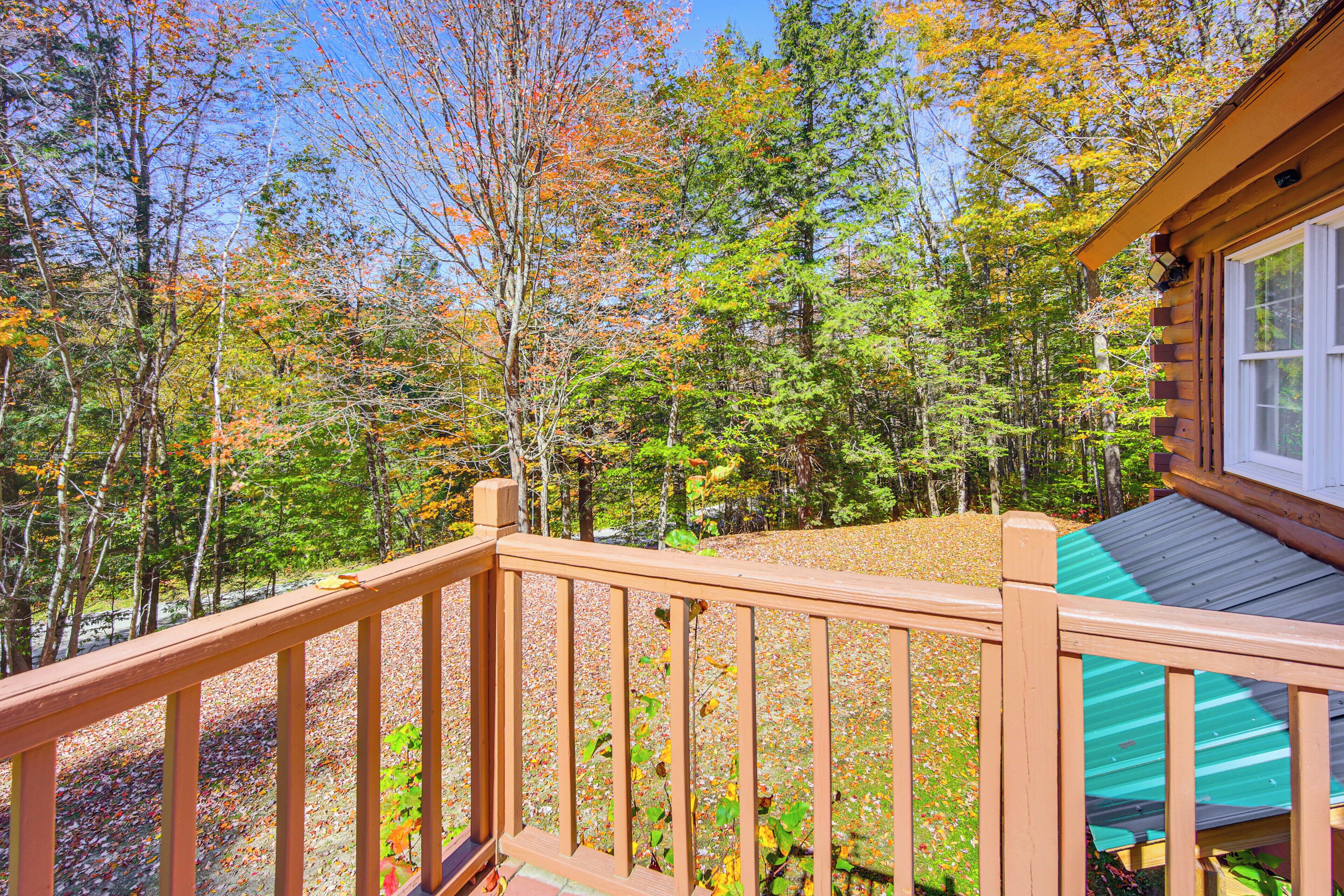 A wooden deck with a view of a forested area.