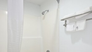 Une salle de bain avec une baignoire, des toilettes et un rideau de douche.