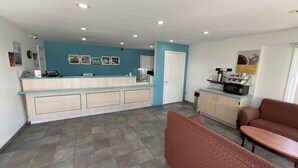 Un espace d’accueil avec un comptoir, une machine à café et des sièges.
