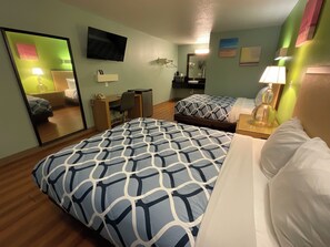 A hotel room with two beds, a desk, a chair, a TV, and a mirror. - Country Yard Inn and Suite (Sikeston)