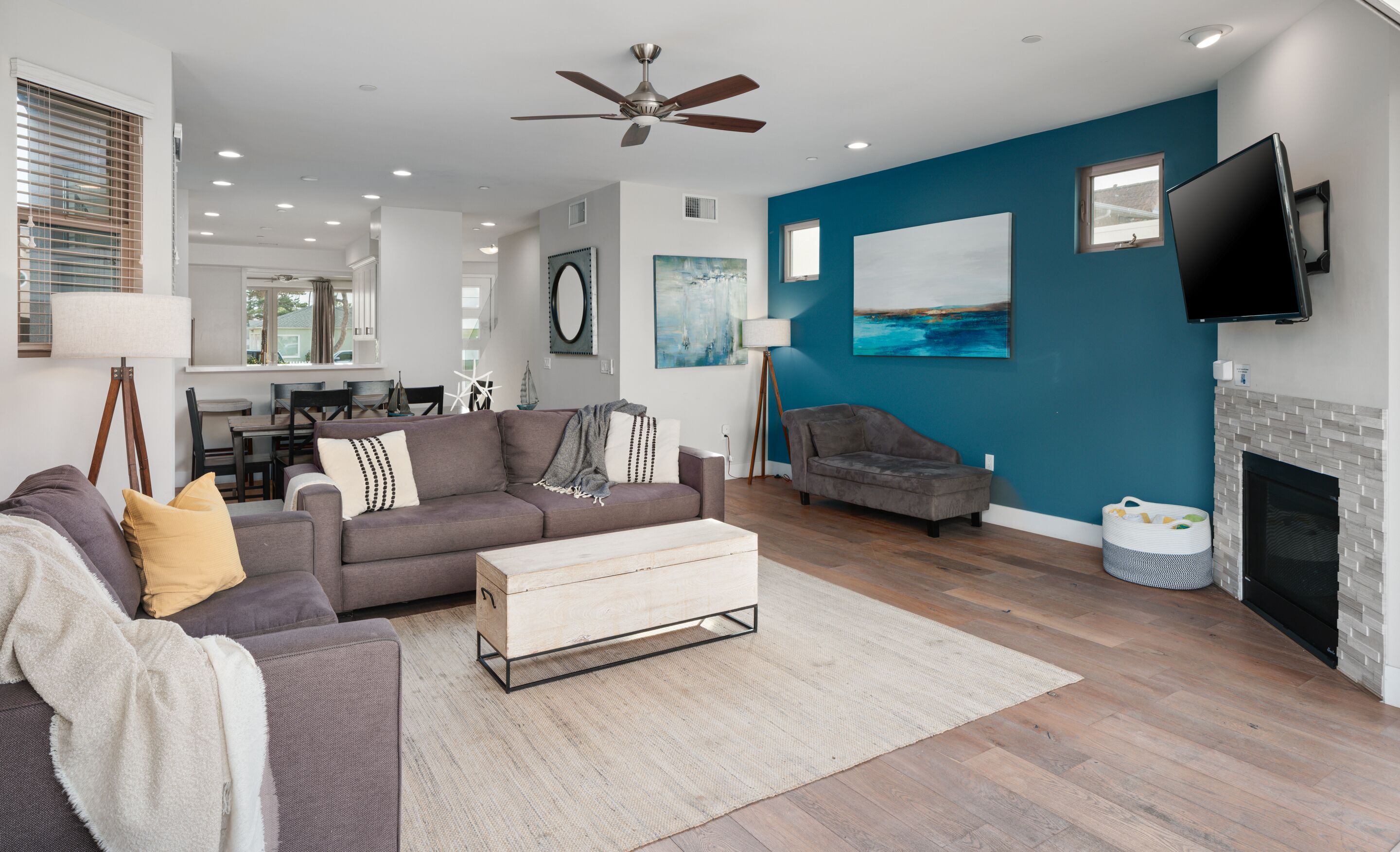 A modern living room with a grey sofa, a wooden coffee table, and a fireplace.