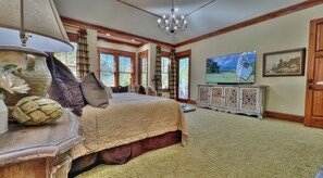 A spacious bedroom with a large bed, a television, and a decorative cabinet. - Stately Mountain View Sanctuary, Private Pool & Hot Tub, Resort Amenities, Fazio Golf Course!   (Mill Spring)