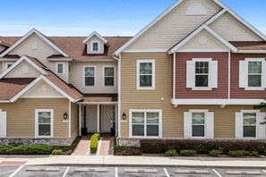 A multi-story residential building with a symmetrical facade, a central entrance, and a parking area in front. - Ultra convenient stay > 5 min to Disney (Kissimmee)