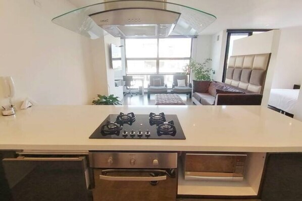Een moderne keuken met een centraal eiland, een ingebouwde oven en een rvs-afzuigkap.