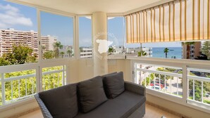 A balcony with a view of the sea and buildings, a sofa, and a window with blinds. - CostaBlancaDreams - Apolo 12, 4e in Calpe (Calpe)