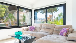 A modern living room with a sofa, a glass coffee table, and large windows offering a view of the outdoors. - CostaBlancaDreams - Mila in Benissa (Calpe)