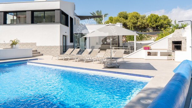 A modern pool area with a clear blue pool, lounge chairs, and a contemporary building with large windows. - CostaBlancaDreams - Mila in Benissa (Calpe)