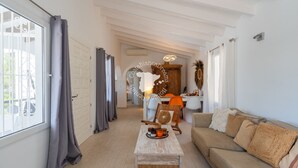 Un salón amplio con un sofá, una mesa de centro y un comedor al fondo.