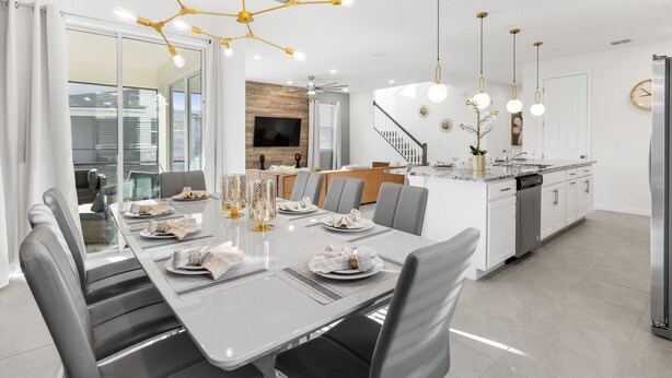 Una cocina moderna con una isla central, muebles de cocina blancos y electrodomésticos de acero inoxidable.