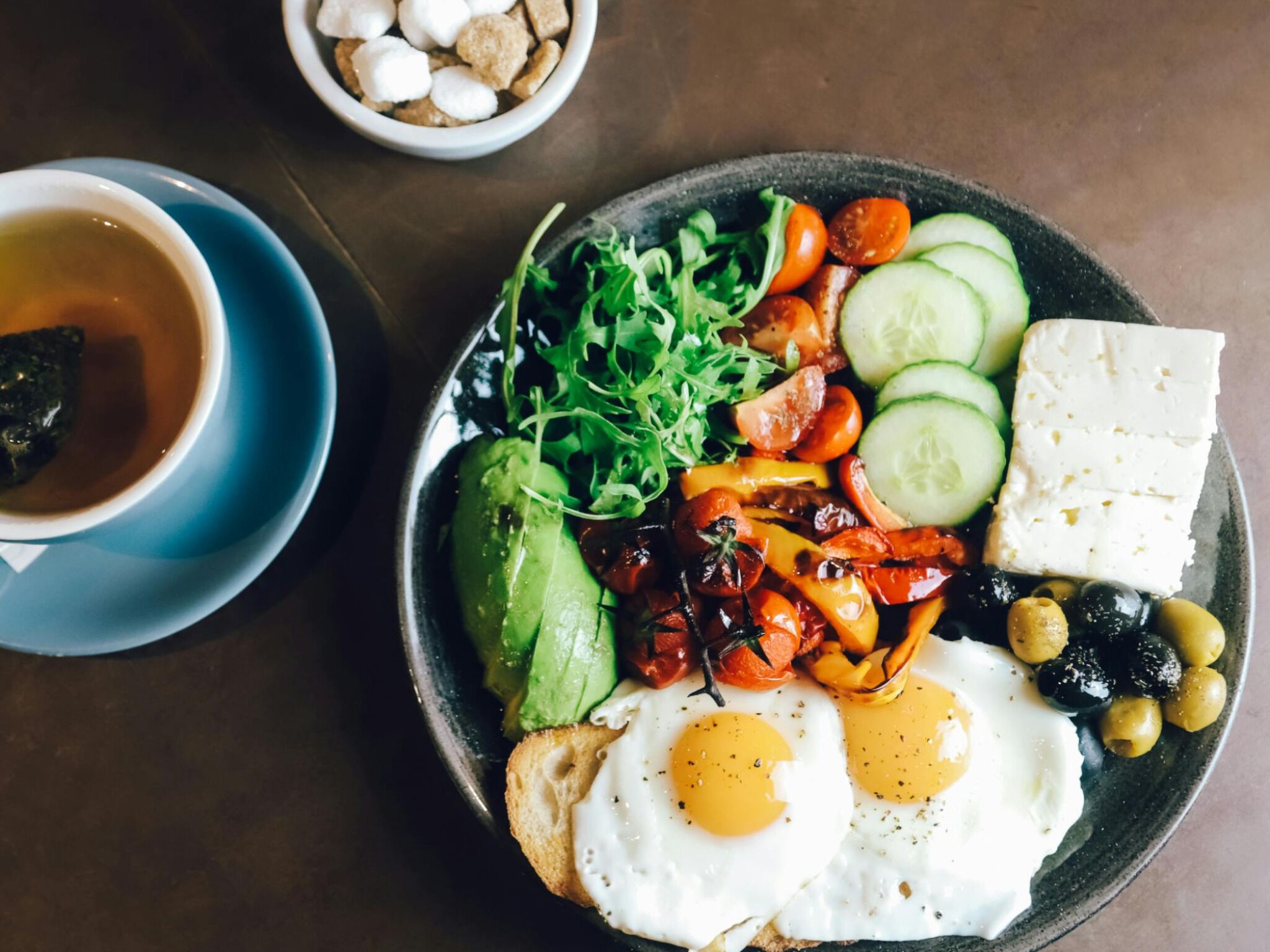 A breakfast plate with eggs, vegetables, and cheese.