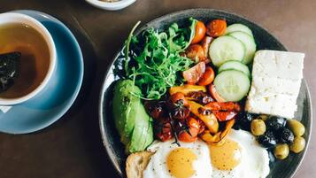 A breakfast plate with eggs, vegetables, and cheese.