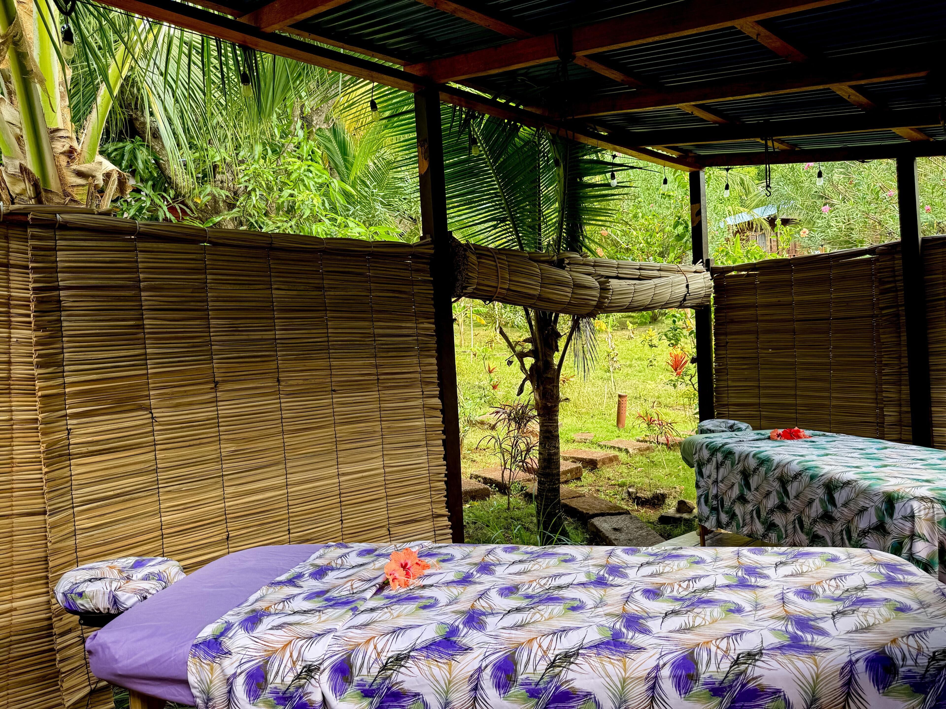 A room with a bed, a table, and a view of a garden.