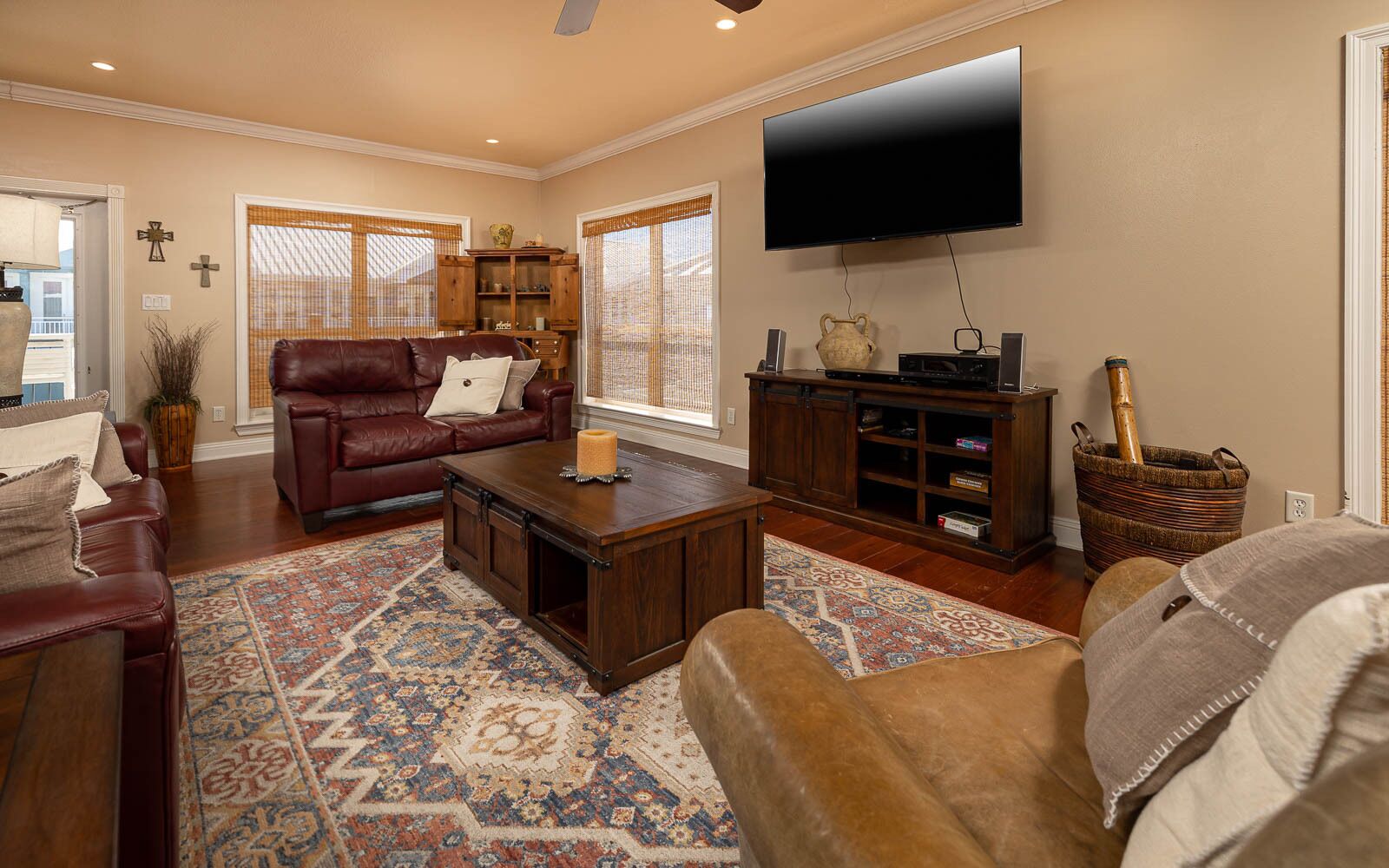 A living room with a leather sofa, a coffee table, a TV, and a bookshelf.