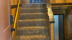 A wooden interior with a carpeted staircase, a handrail, and directional signs indicating 'Holiday', 'Grouse', 'Paradise', 'Mach V', and 'Hourglass'. - Spacious Family Vacation Retreat! (Packwood)