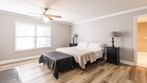 A bedroom with a bed, bedside tables, a ceiling fan, and a window with blinds. - Family Friendly Farm House- 10 minutes from WEC (Ocala)