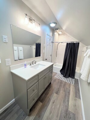 Un bagno moderno con lavabo doppio, un ampio specchio e zona doccia.