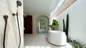 A modern bathroom with a shower, a bathtub, and a pool area. - Breathe Boutique (Pecatu)