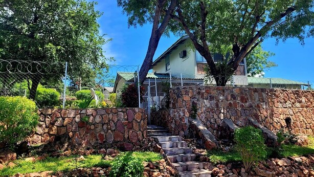 A stone staircase leading to a house with a stone wall and barbed wire fence. - The View - Heights, Kariba  (kariba)