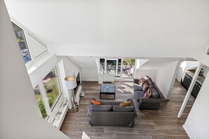 A spacious loft apartment with a large open-plan living area, a dining area, and a kitchen.