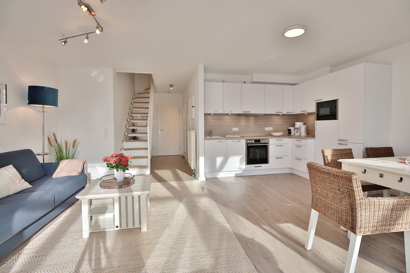 Um apartamento moderno com sala de estar, cozinha e área de jantar.