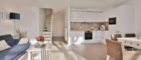 Um apartamento moderno com sala de estar, cozinha e área de jantar.