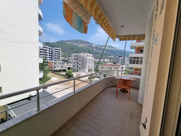A balcony with a view of a cityscape and mountains.