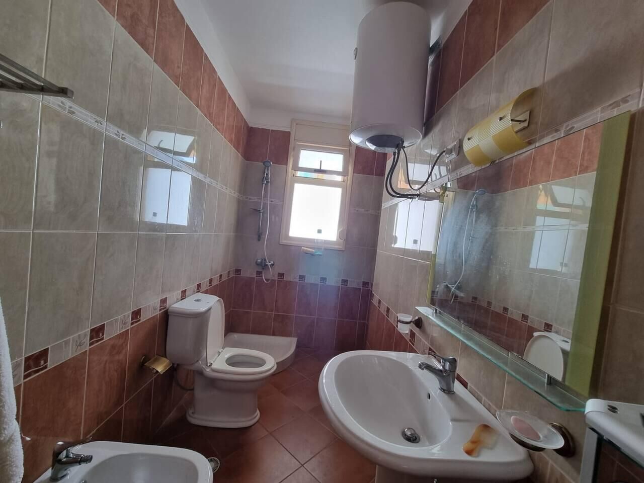 A bathroom with a toilet, bidet, and sink.