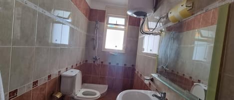 A bathroom with a toilet, bidet, and sink.