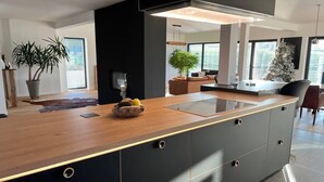 A modern kitchen with a wooden countertop, black cabinets, and a central island. - House - Sleeps 8 - Pets Ok - Garden - Parking (Berdorf)