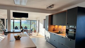 A modern kitchen with dark cabinetry, a wooden countertop, and a built-in oven. - House - Sleeps 8 - Pets Ok - Garden - Parking (Berdorf)