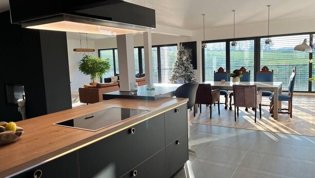 A modern kitchen with a central island, large windows, and a dining area with chairs and a table. - House - Sleeps 8 - Pets Ok - Garden - Parking (Berdorf)