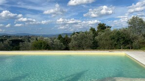 Ein klares Schwimmbecken mit Blick auf weit entfernte Hügel und Bäume.