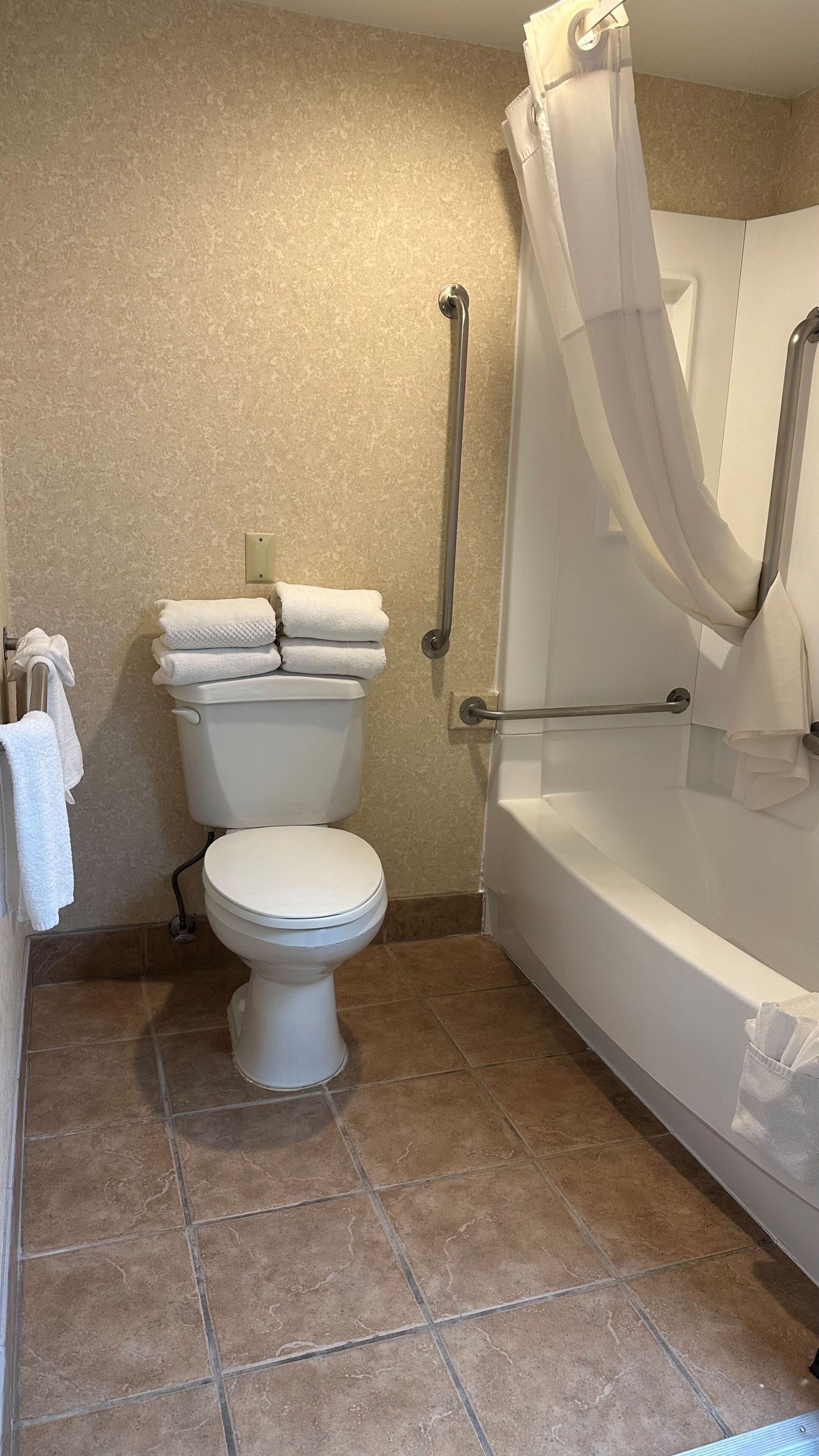 A bathroom with a toilet, a bathtub, and a shower curtain.