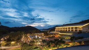 A hotel with a large building, a parking area, and a view of the surrounding landscape. - Howard Johnson By Wyndham Dongqian Lake Plaza Ningbo (Ningbo)