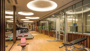 A gym with exercise equipment, wooden flooring, and large windows. - Howard Johnson By Wyndham Dongqian Lake Plaza Ningbo (Ningbo)