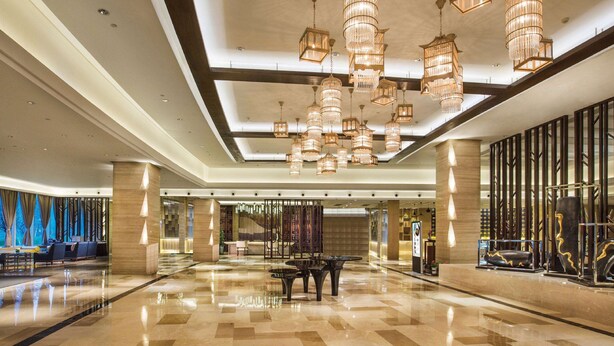 A spacious lobby with a polished marble floor, multiple seating areas, and a grand chandelier. - Howard Johnson By Wyndham Dongqian Lake Plaza Ningbo (Ningbo)