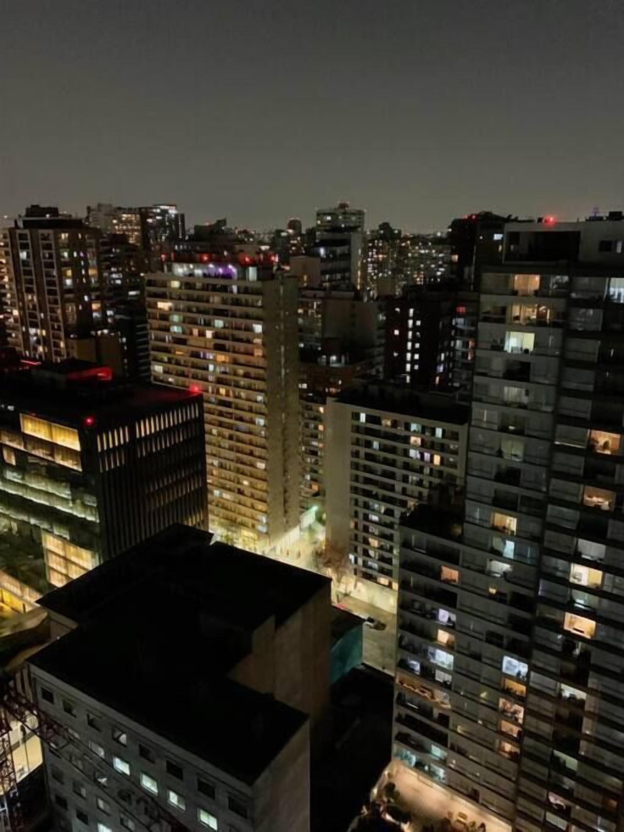 A high-rise building with multiple floors, each illuminated by interior lights.