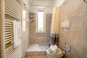 A bathroom with a shower, a toilet, a towel rack, and a window. - Il Sogno Di Silvana w/ Private Terrace, Sanremo, Italy (Sanremo)